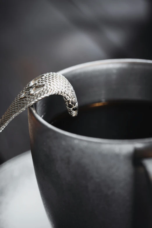 a snake crawling out of the middle of a mug