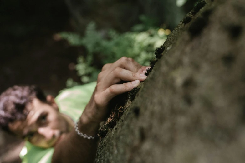 a man looking down and putting soing on his wrist