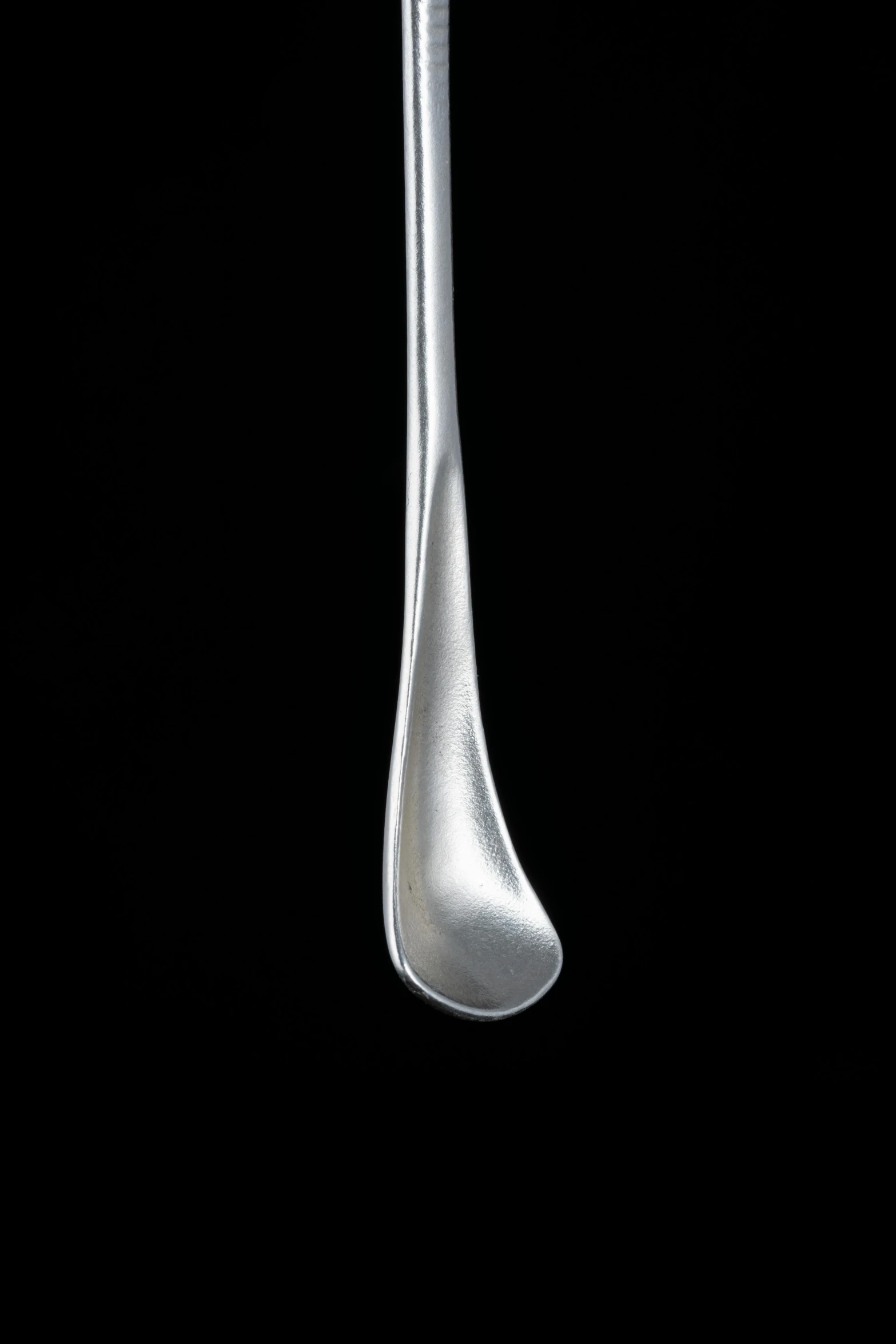 a white spoon with very long handles and two pointed ends