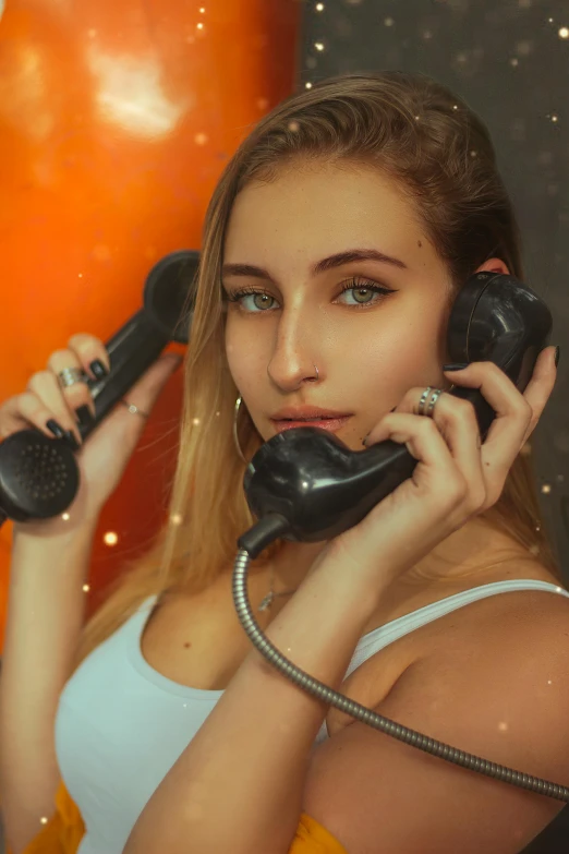 a woman holding up two old style telephones