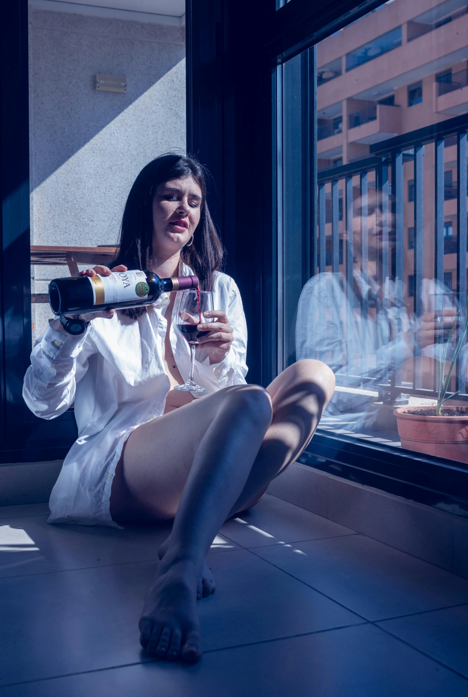 a woman sitting down with a bottle in her hand