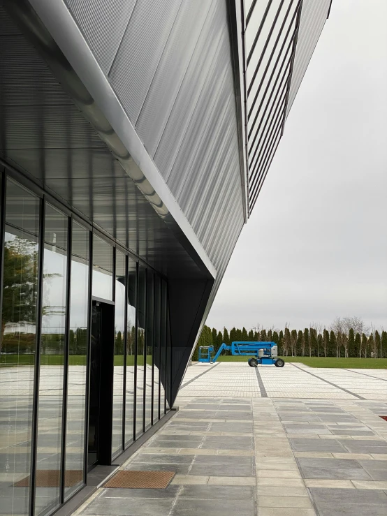 a glass enclosed parking space between a building and grassy area