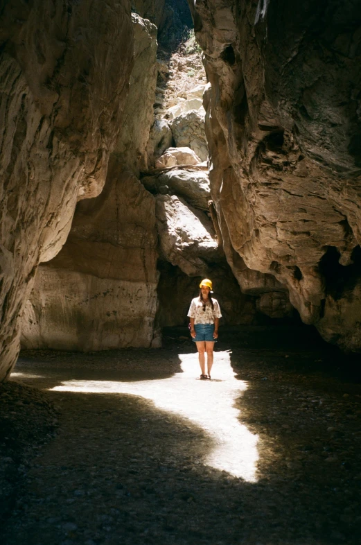 the young person is walking through a narrow path