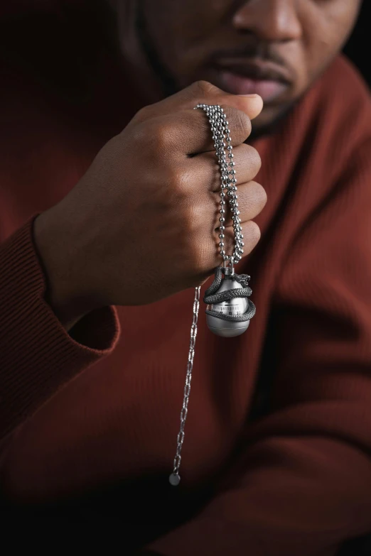 a man holding onto a bell with a chain