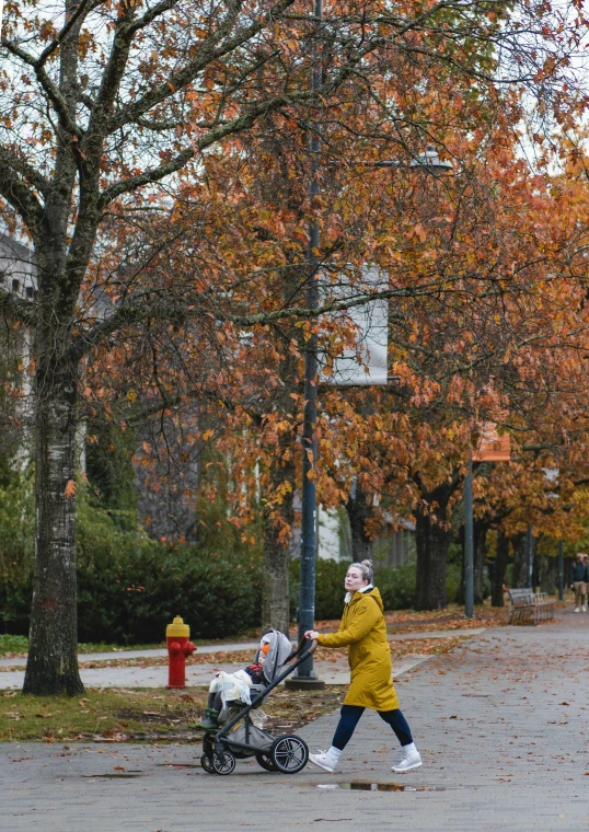 a woman walking down the street holding onto a stroller