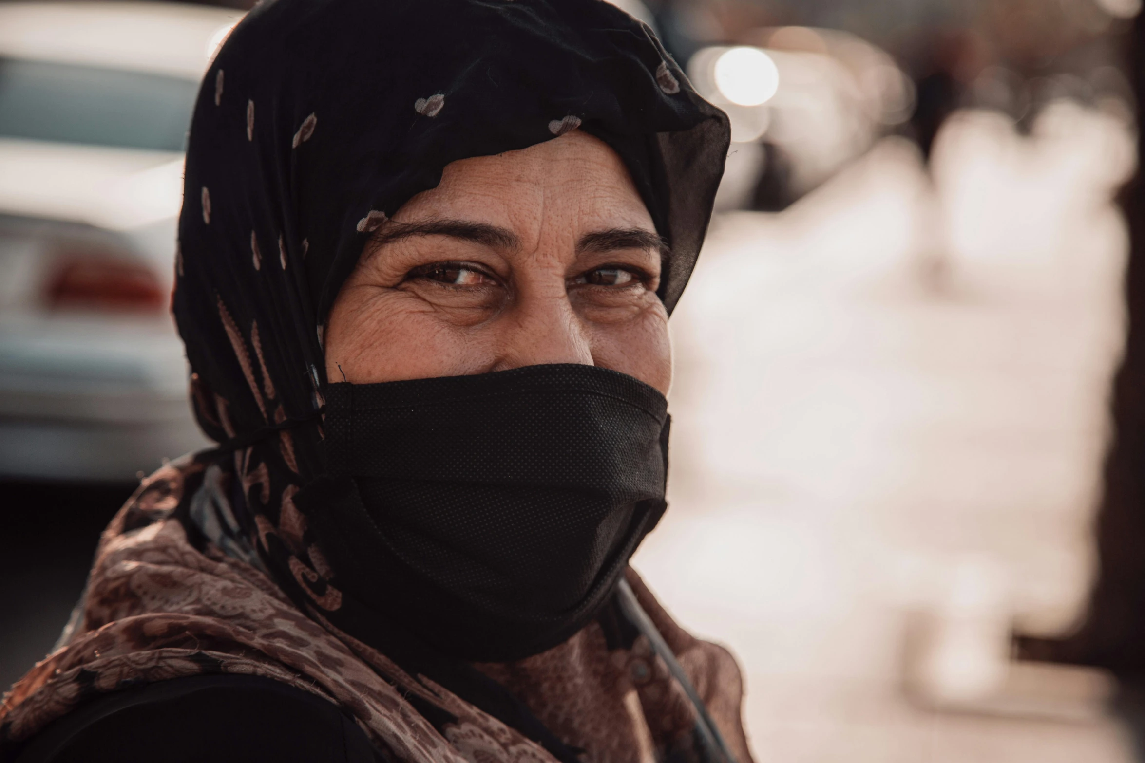 an older woman wears a black headscarf