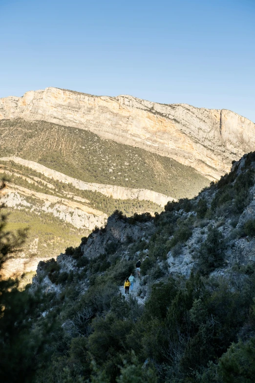 there is a man walking on the mountain trail