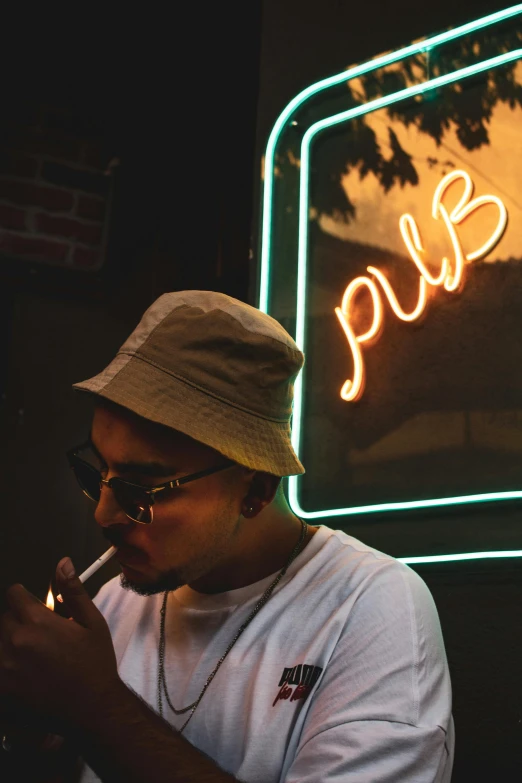 a man standing in front of a neon sign and smoking a pipe