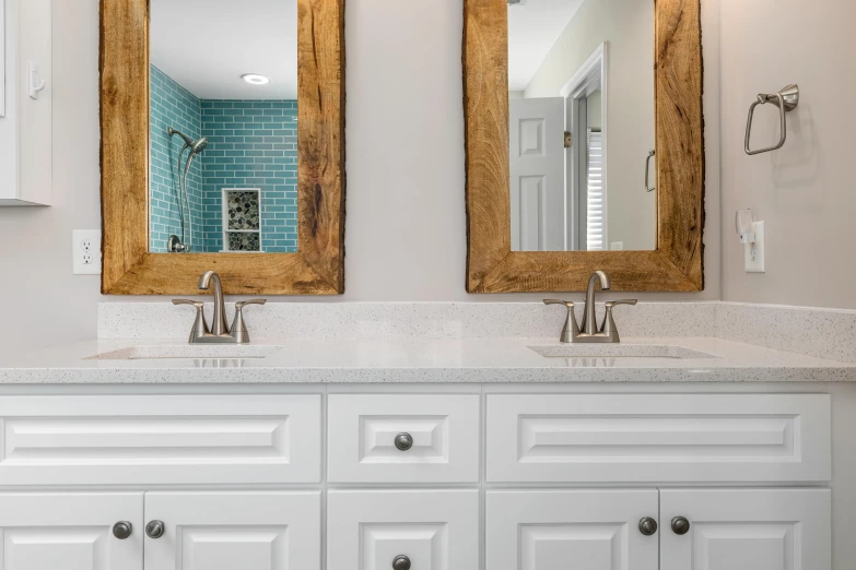 two large mirrors that are in the middle of a bathroom