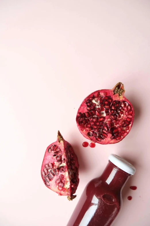 a bottle of juice and a pomegranate