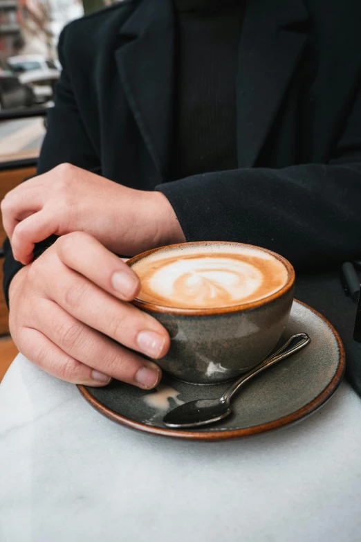 a man is sitting with his cup of cappuccino in front of him