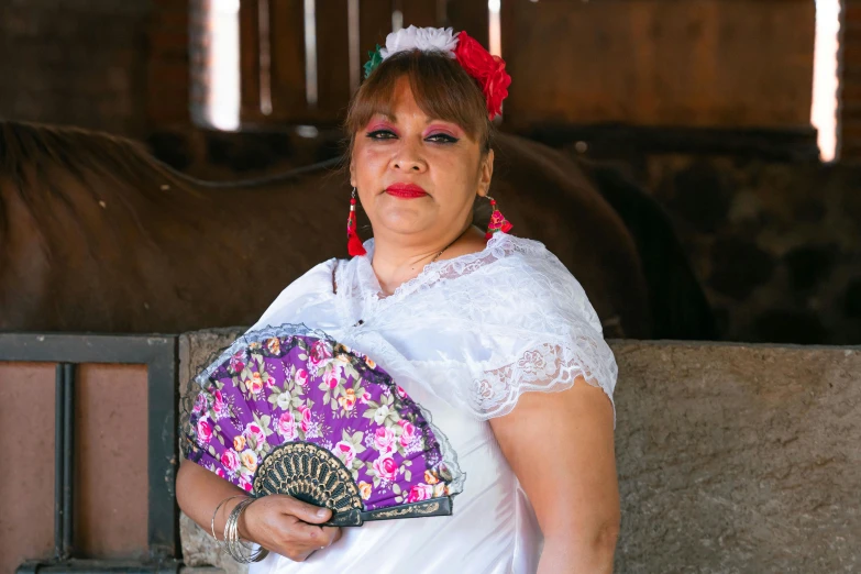 a woman dressed in white holding a purple and pink fan