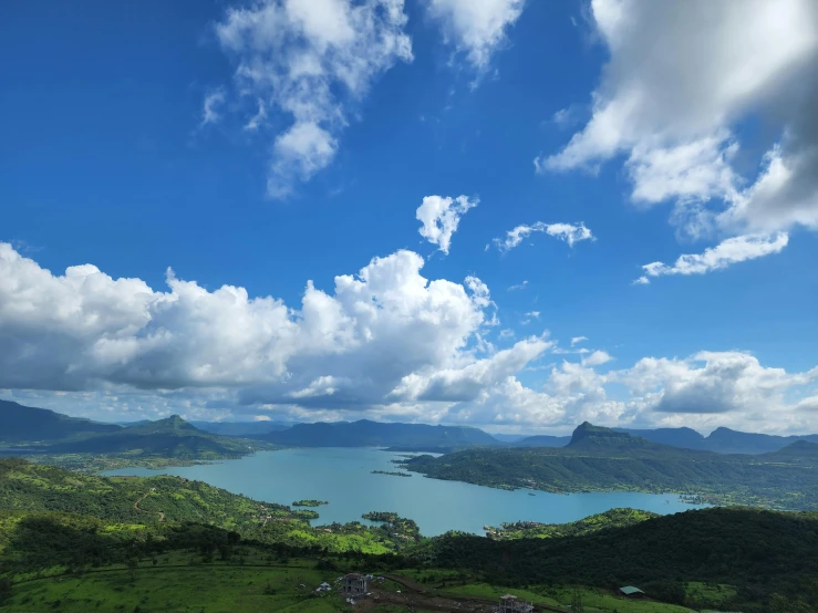 green valley with blue water under a cloudy sky