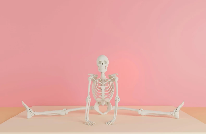 a skeleton sitting on a table with hands and bones spread out