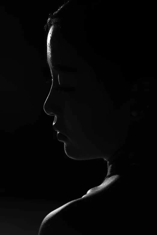 the silhouette of a young woman with a nose ring