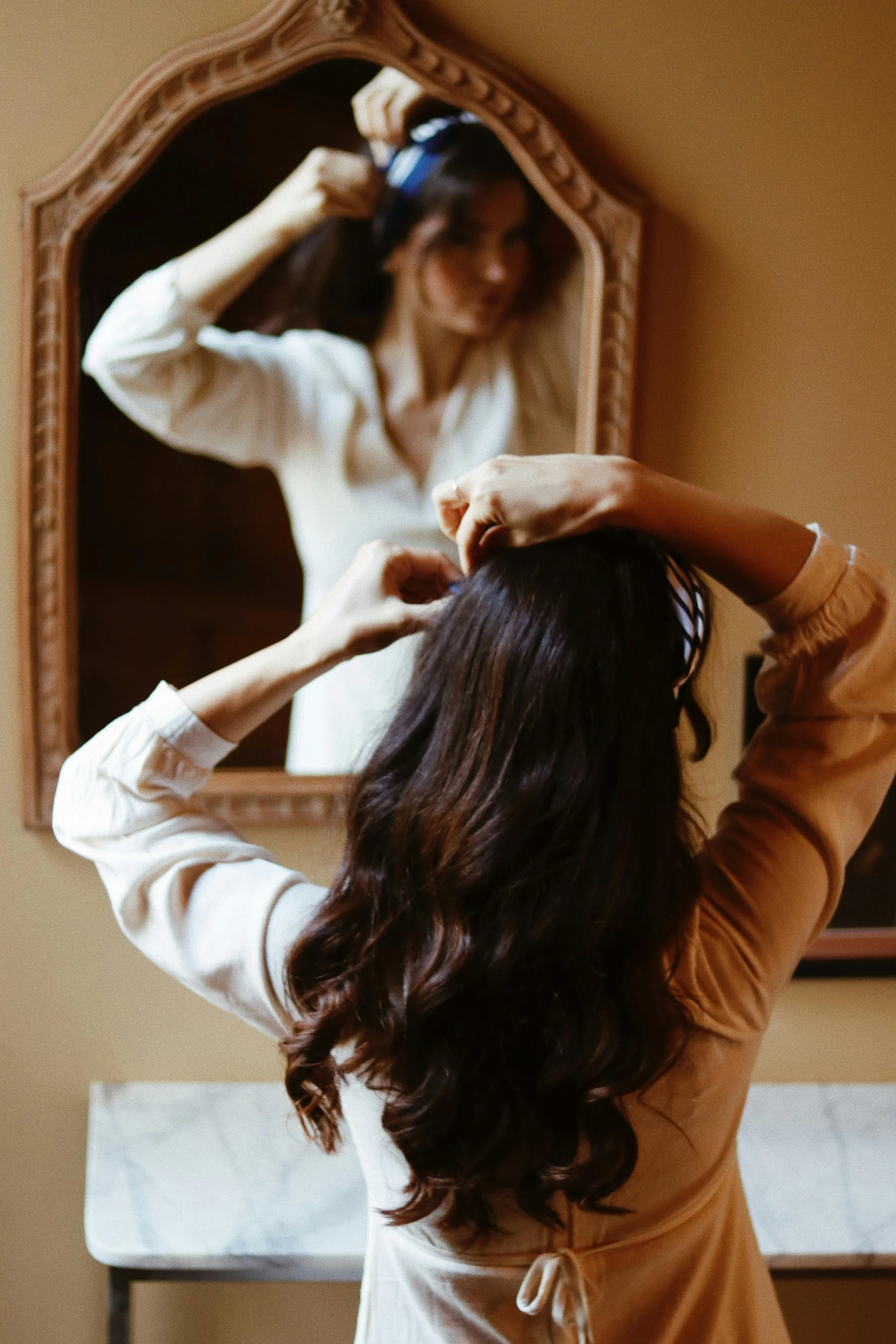 a person that is standing up with her hair in her hands