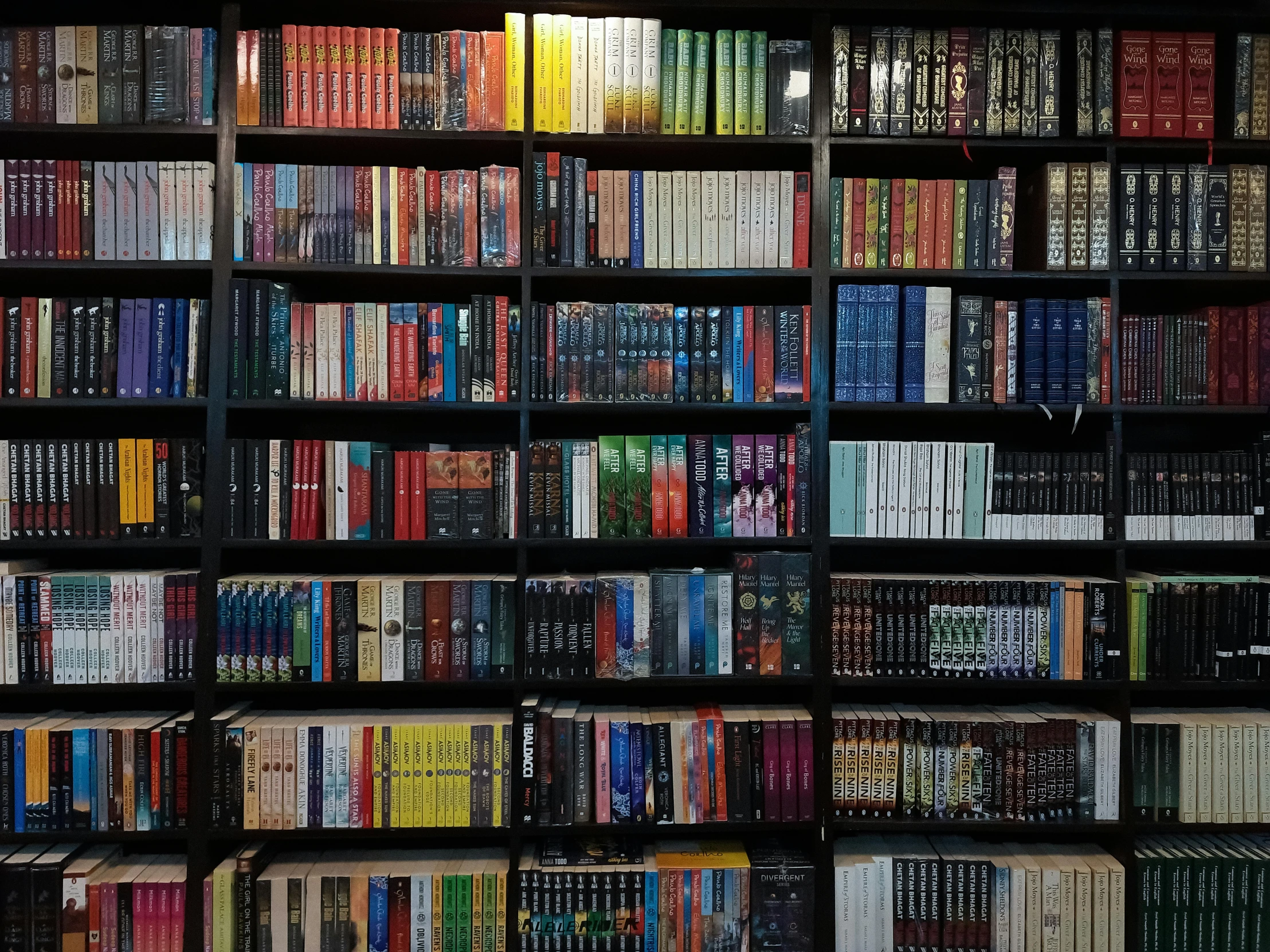 a large long bookshelf filled with lots of books