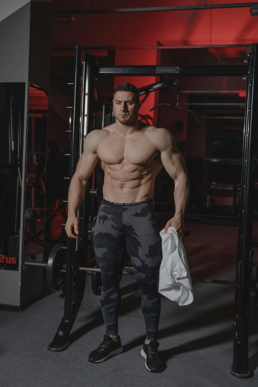 shirtless, strong man holding a bag in gym