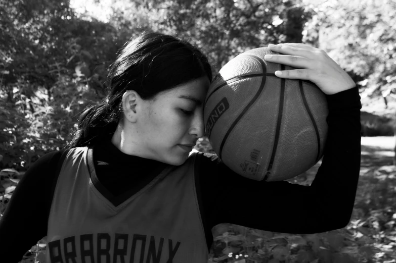 a young woman holding a basketball and ball