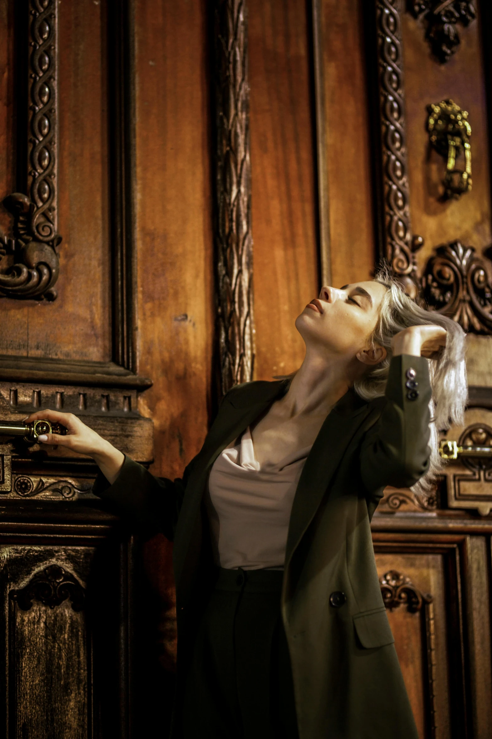 a woman is pointing at the door handle of a building