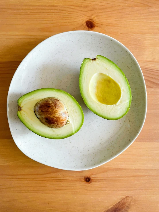 an avocado is cut into half on a plate