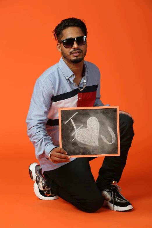 a man is holding up a chalk board in front of him