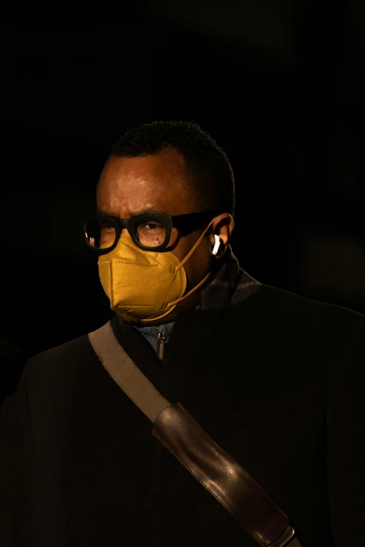 man in a black top, glasses, and a mask