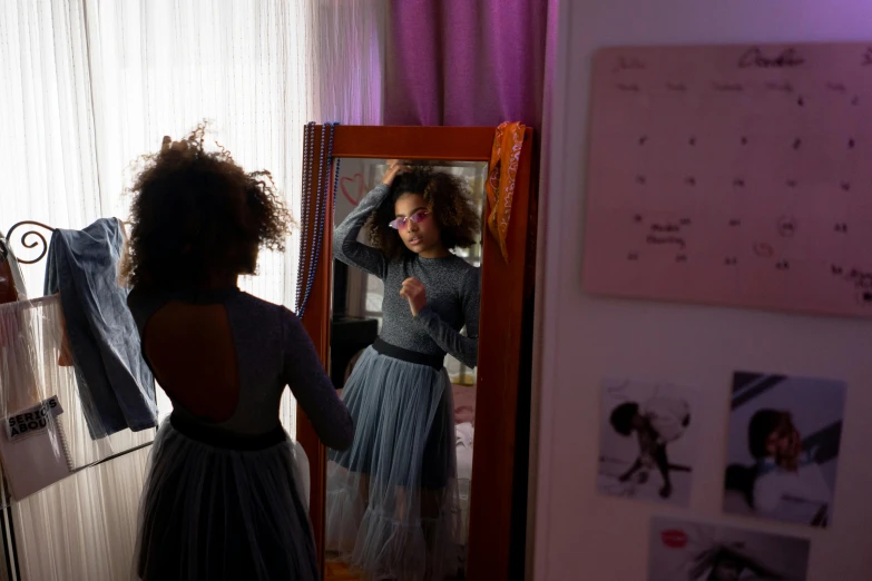 a woman is standing in a room looking in the mirror