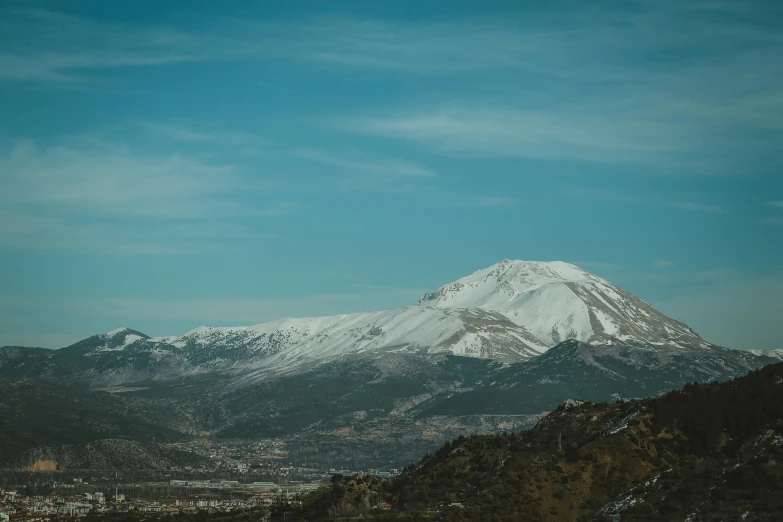 the snow - capped mountain is the highest in the view