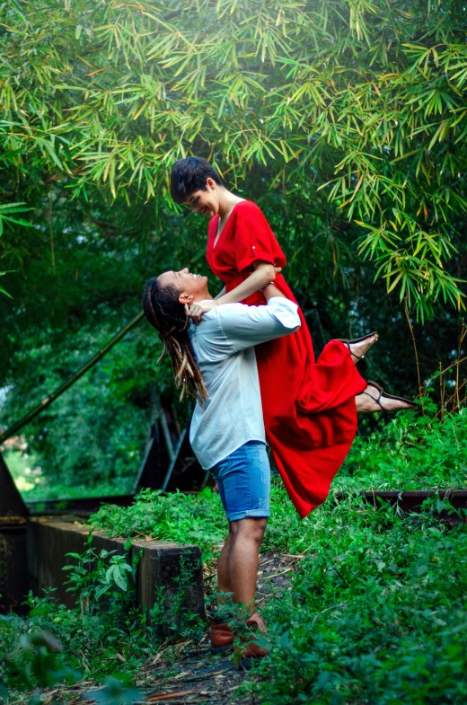 a man in red shirt carrying a woman with his back