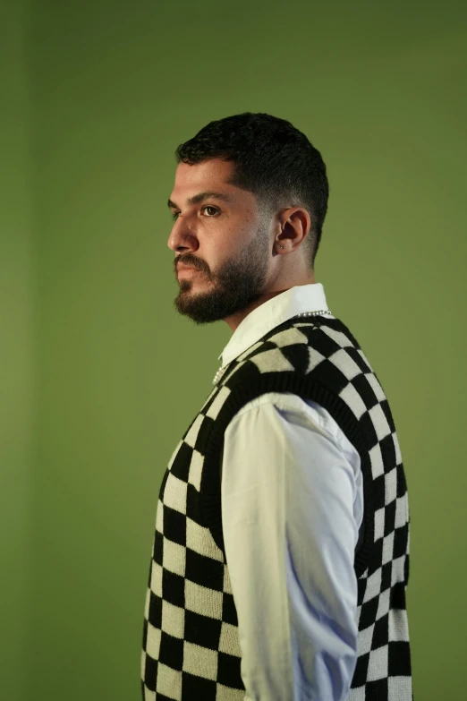 a man in a checkered vest stares ahead