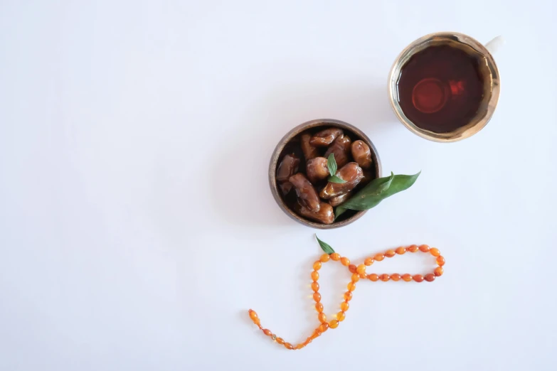 a cup of tea next to some beads