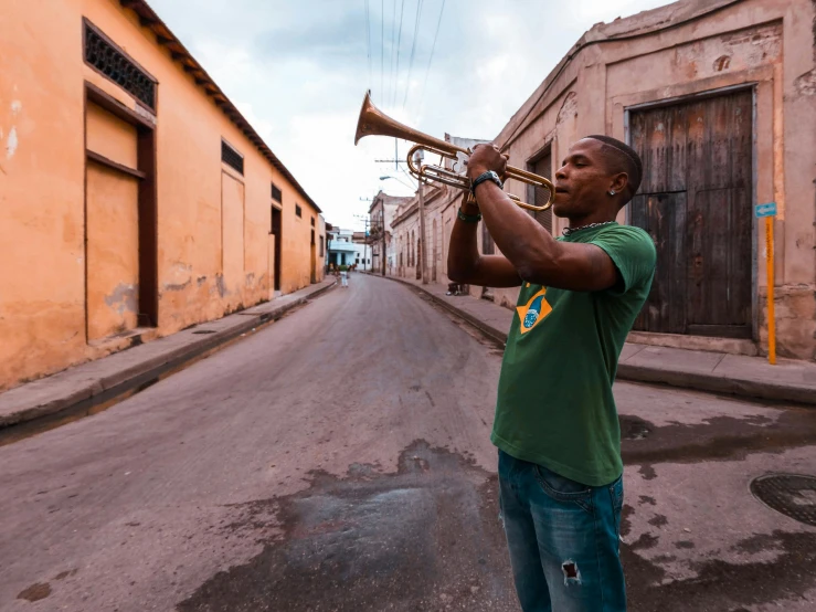 an african american man playing a trombone on an empty street