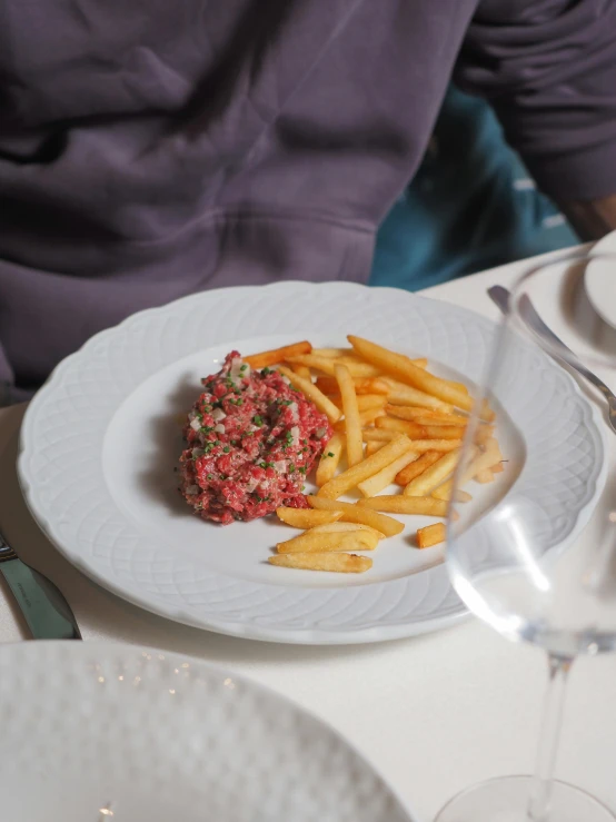 fries with a dipping sauce sit on a plate