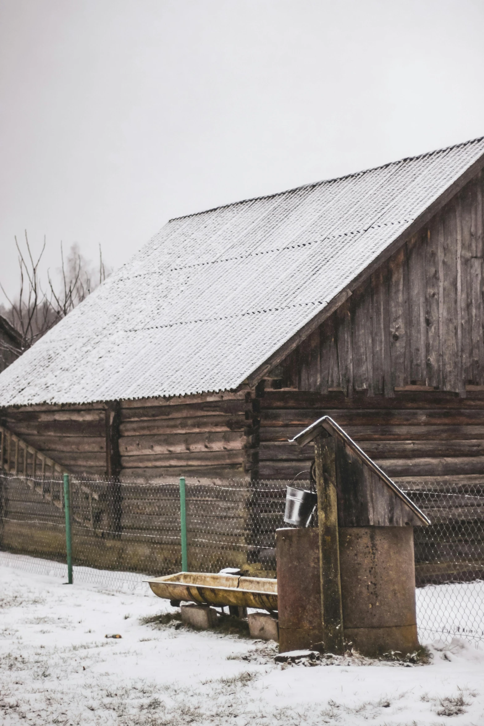 there is a wooden barn and a large building