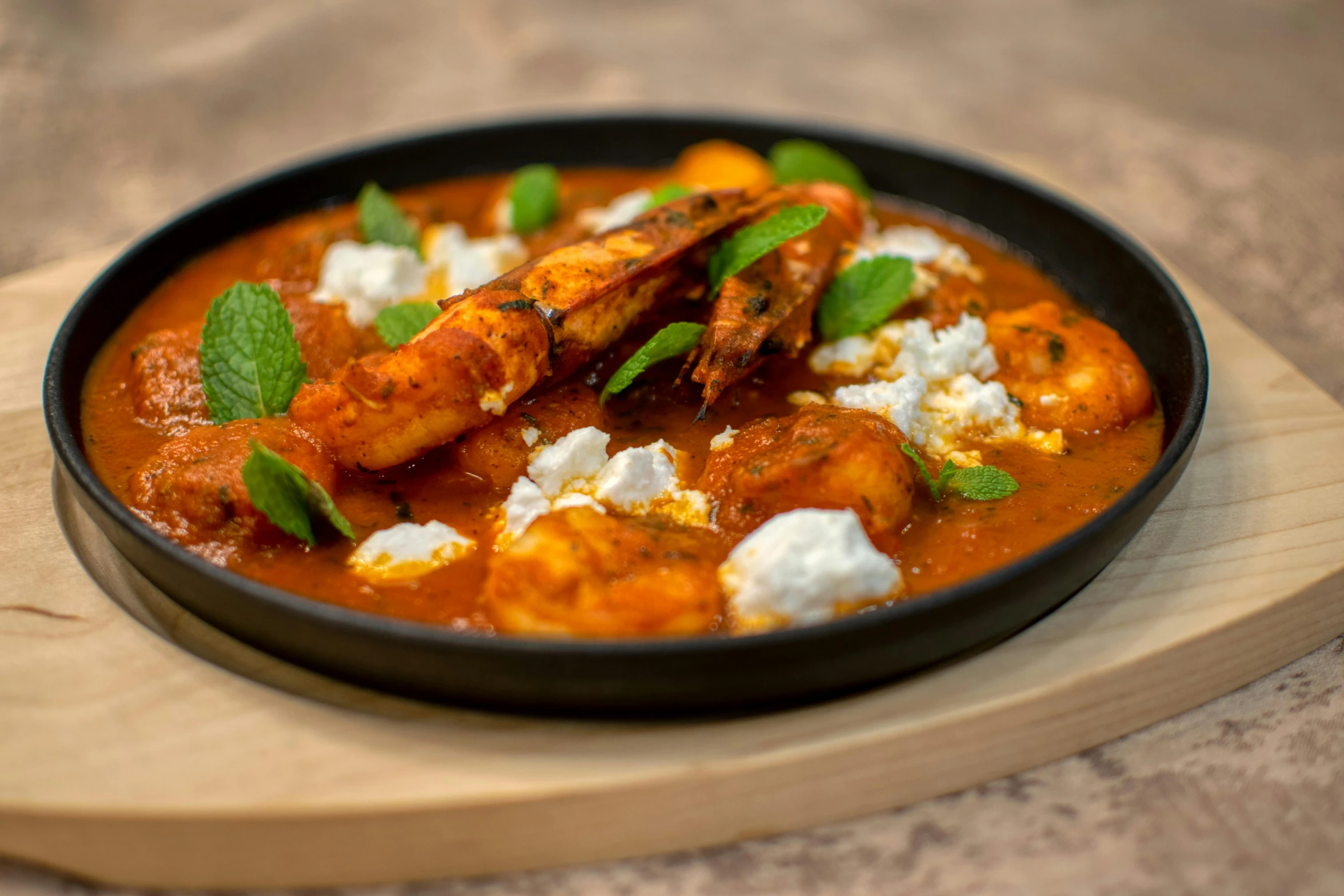 chicken tikka and yogurt on a wooden plate