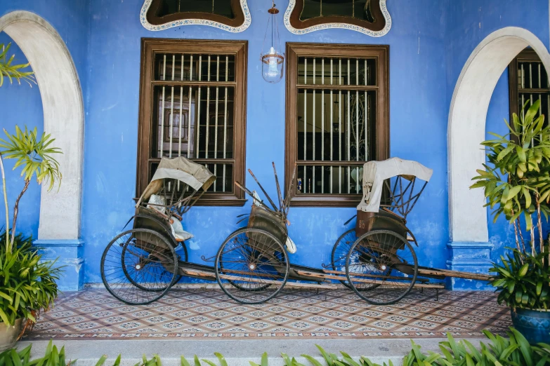 three bikes and bicycle parts sitting next to a building