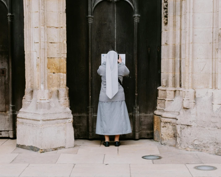 a person standing by a doorway reading soing