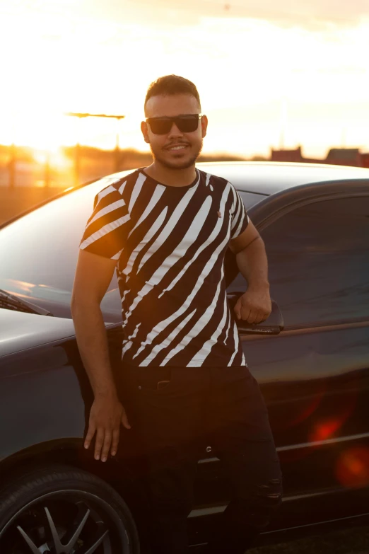 a man posing next to a car on the road