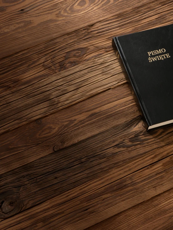 a brown wooden table holding a black passport