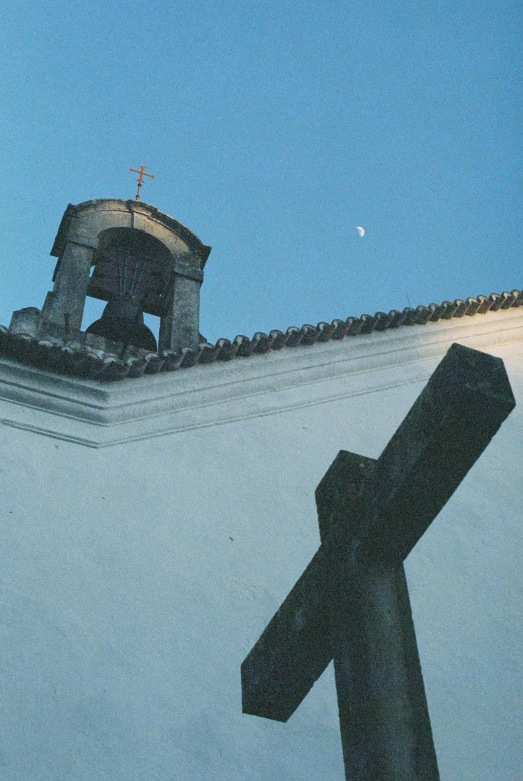 a cross on a wall with a small sky in the background