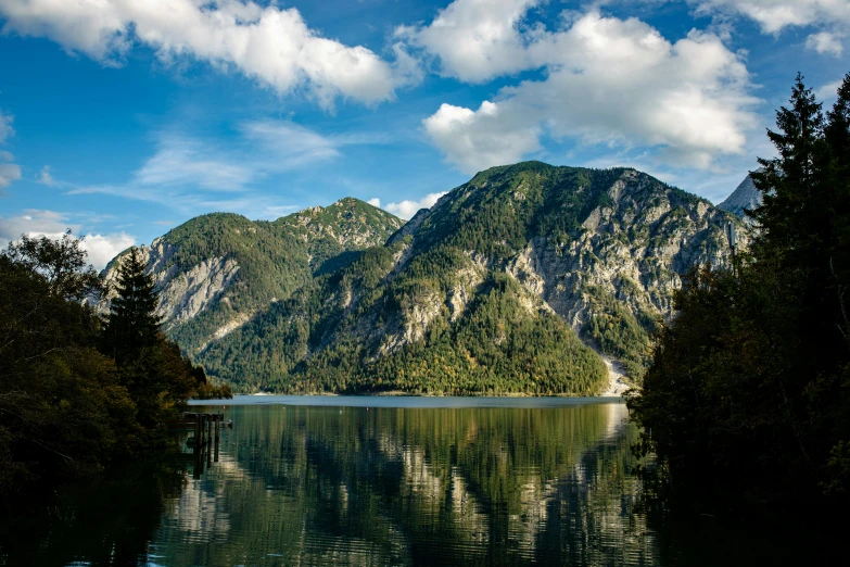 the view of a mountain range from a lake with reflections