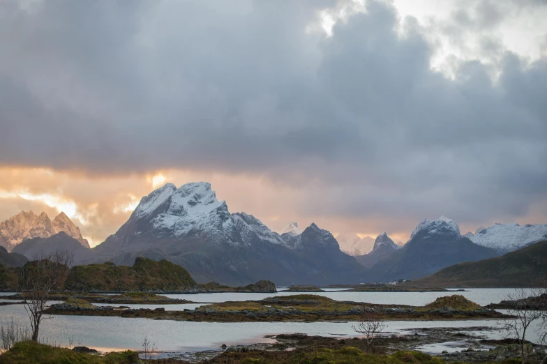 snow covered mountains and lakes during sunset with clouds