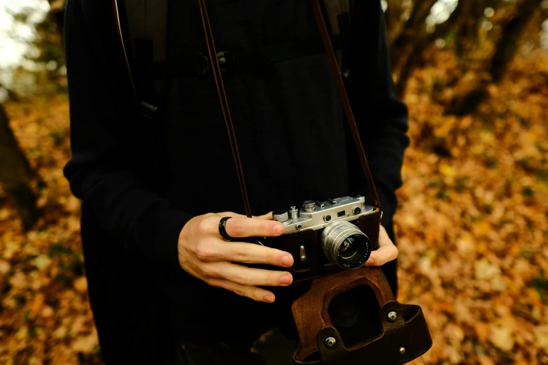 a person is holding a camera with the lens on their hand