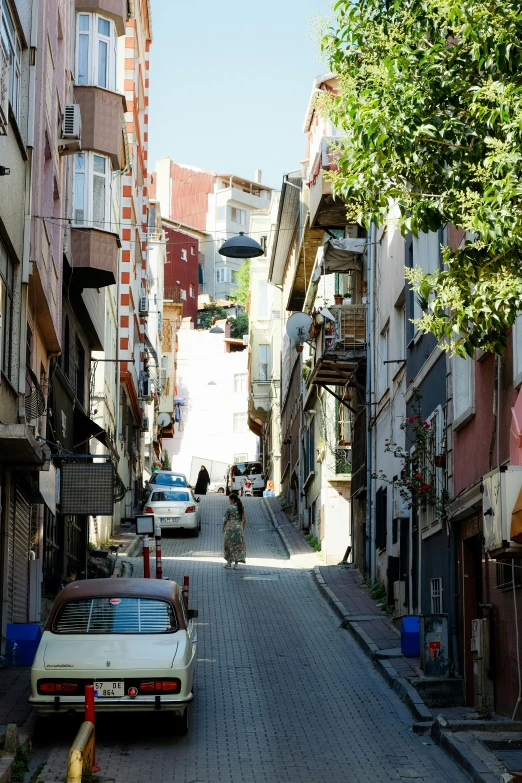 an old woman walking down a narrow street in an urban area