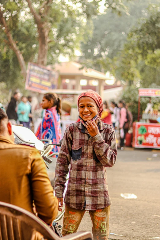 a woman in a colorful coat smiling while talking on her cell phone