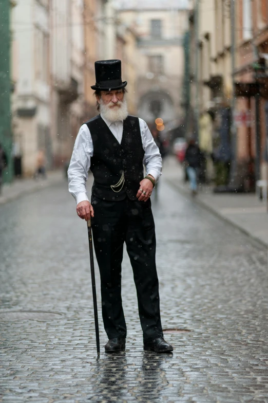 an old man standing alone holding a cane in the rain