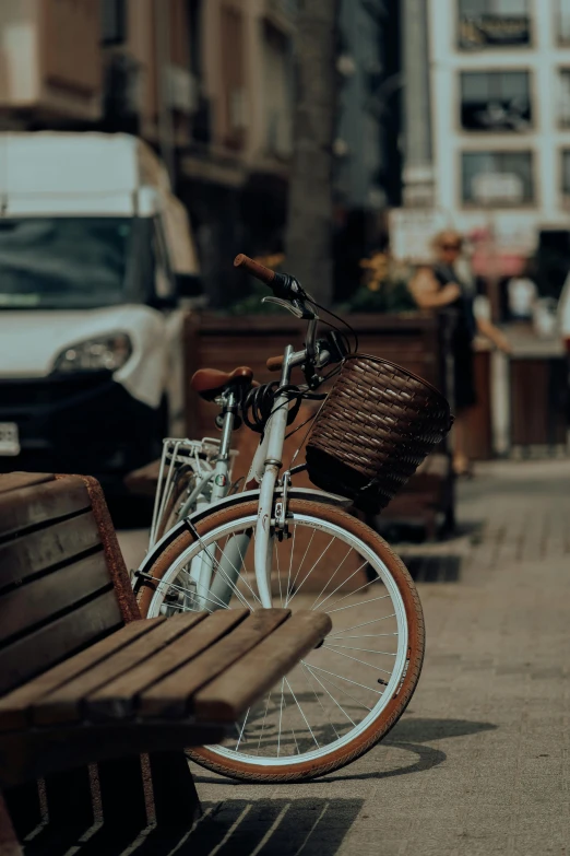 a bike leaning up against a bench on a sidewalk