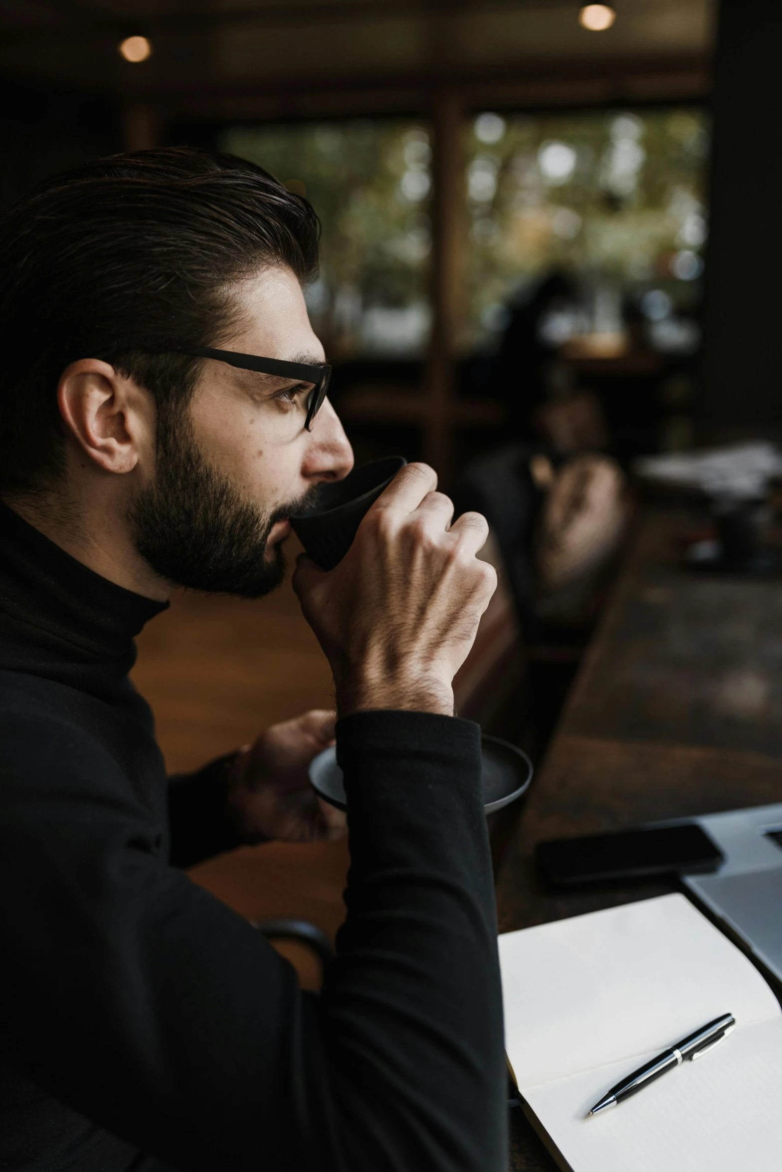 a man sitting at a table with a pen and notebook