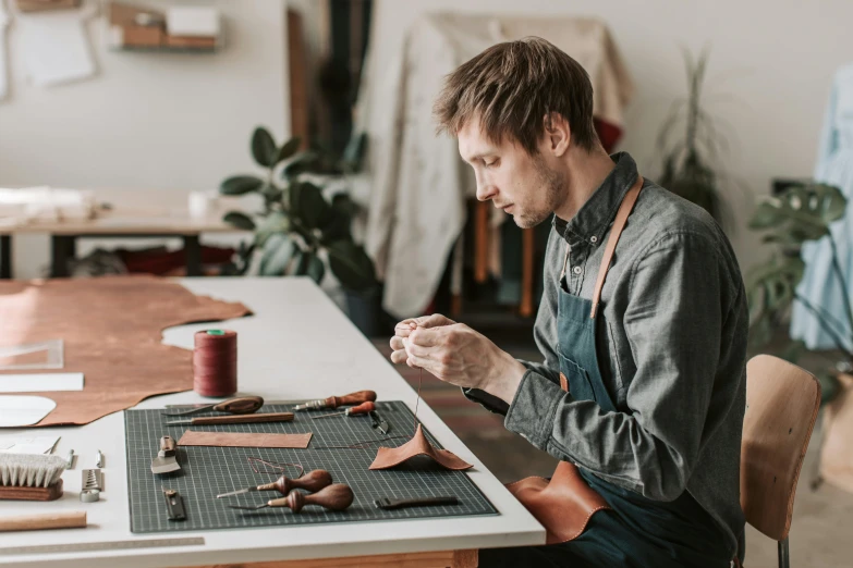 a man is sitting down at a table making soing